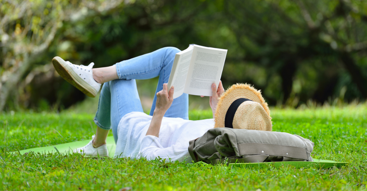 vrouw leest boek in park
