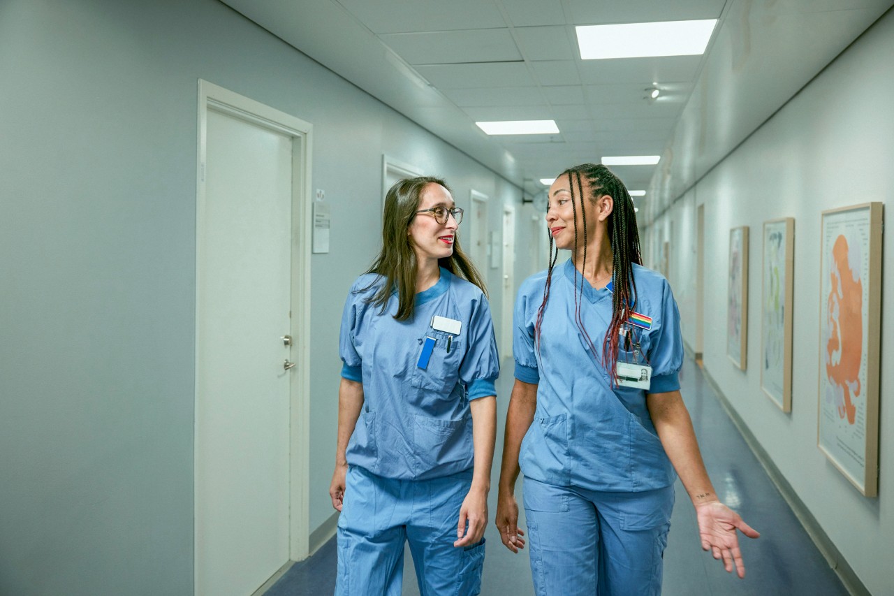 Twee verpleegkundigen in overleg in gang ziekenhuis