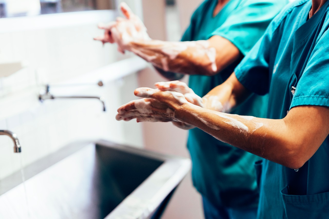 Medisch personeel wast handen voor operatie